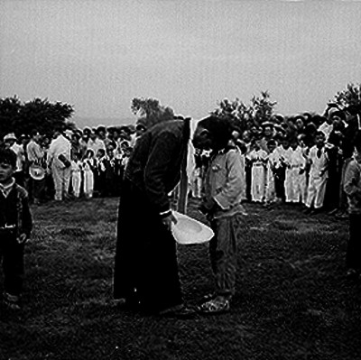 Niño confesándose con un sacerdote en el campo