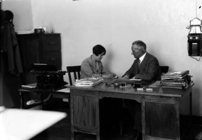 Funcionario dicta a su secretaria en una oficina