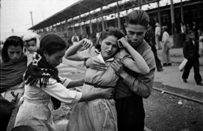 Hombre sujetando a una mujer en la estación del ferrocarril al despedirse de un emigrante