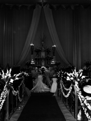 María Cristina Olmos y su prometido reclinados ente el altar, en su boda
