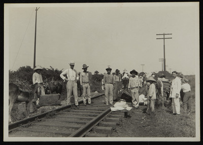 Hombres con equipajes sobre las vías del ferrocarril con dirección a Veracruz