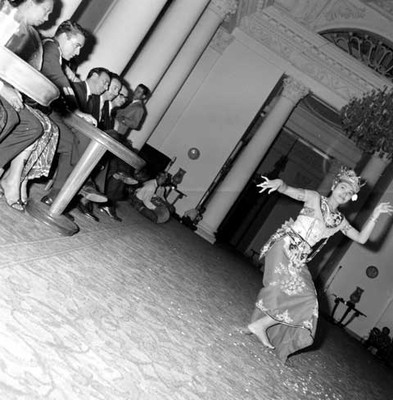 Bailarina indonesa durante evolución de danza folclórica en un salón