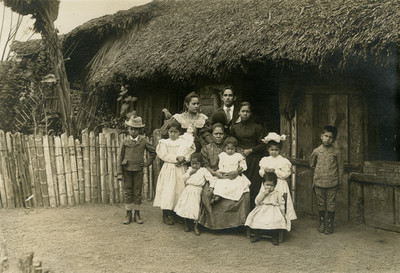 Familia afuera de una choza, retrato de grupo