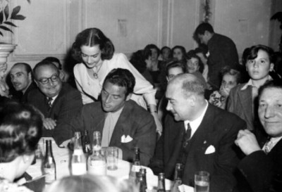 Jorge Mistral dando autógrafo a señorita durante un banquete