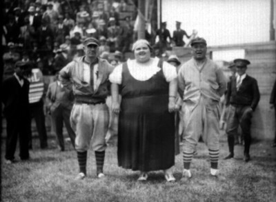 Tini Griffith posando con dos beibolistas, durante un juego en un estadio, retrato