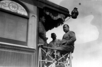 Álvaro Obregón [junto a dos hombres] en la plataforma del tren presidencial