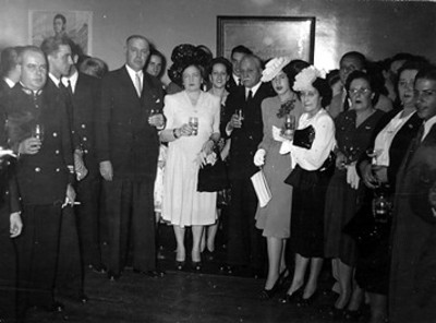 Diplomaticos acompañados de sus esposas durante un brindis