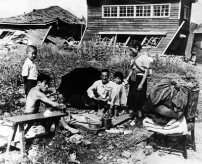 Familia japonesa en poblado destruido por bombardeo, retrato de grupo