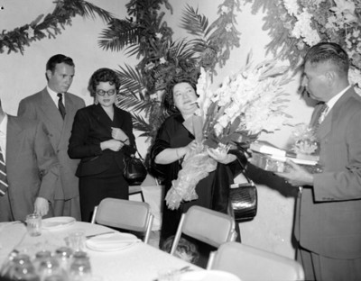 Mujer recibe flores y regalos durante una fiesta