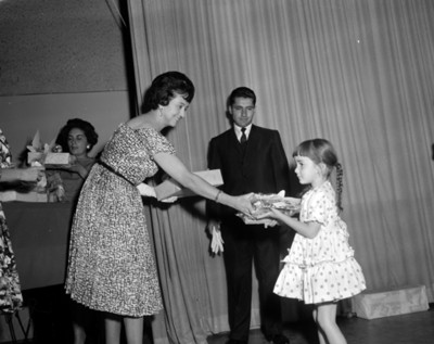 Eva Sámano de López Mateos entrega a una niña del INPI durante ceremonia