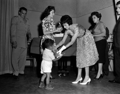 Eva Sámano de López Mateos entrega juguete a un niño del INPI durante una ceremonia
