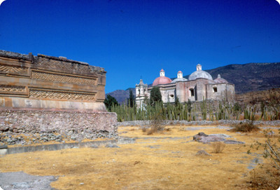 Muro con grecas, detalle, al fondo la iglesia