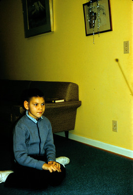 Niño sentado en el piso de una sala, retrato