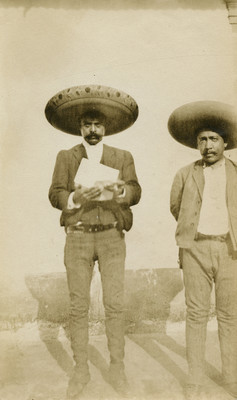 Emiliano Zapata lee documento, acompañado de Manuel Palafox