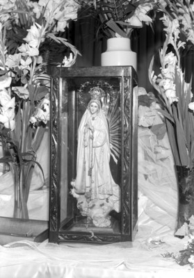Virgen en un nicho rodeada de flores