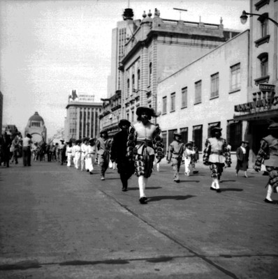 Hombres con disfraces desfilan por avenida Juárez
