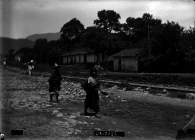 Mujeres indígenas caminan a la orilla de una vía férrea
