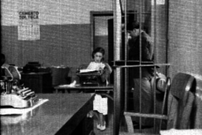Secretaria leyendo documentos a un detenido en un separo
