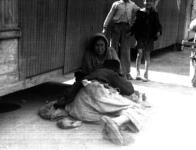 Hombre indigente tirado junto a una mujer de edad