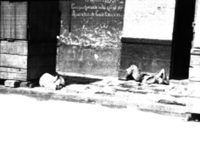 Hombres indigentes tirados sobre una acera