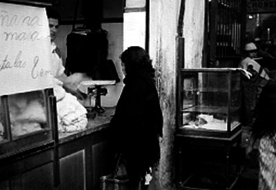 Mujer de condición humilde comprando masa de maíz en una tortillería en el interior de un mercado