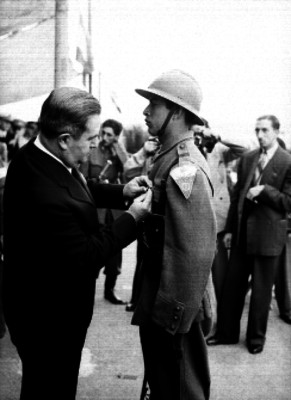 Manuel Ávila Camacho condecora a soldado en el campo militar número 1, durante la despedida de los conscriptos