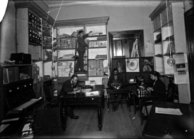 Mujeres y hombres en sala de redacción de un periódico o de una revista