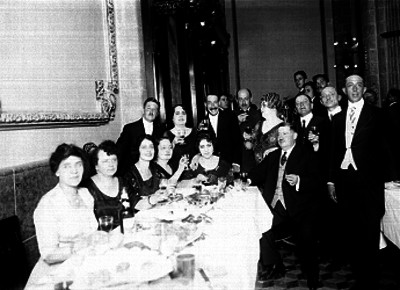 Personas brindan durante un banquete español en un salón, retrato de grupo