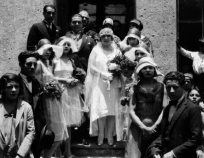 Novios acompañados de gente, en las escaleras de una casa