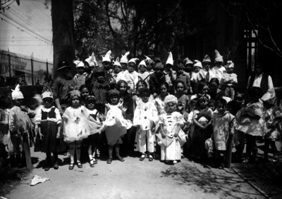 Niños y niñas con diferentes disfraces en el patio de una escuela, retrato de grupo