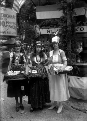 Vendedores ambulantes con canastas y trajes folclóricos, junto a un puesto de Loteria americana, retrato