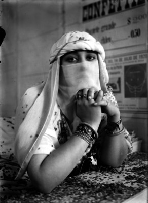 Mujer con un atuendo árabe, en un puesto de confeti durante una kermes, retrato