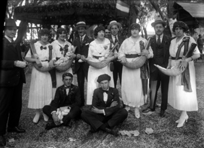 Vendedores acompañados de hombres durante una kermesse de la colonia española, retrato de grupo