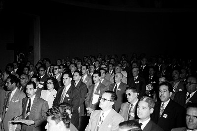 Banqueros de pie en un auditorio durante una convención en Guadalajara, Jal