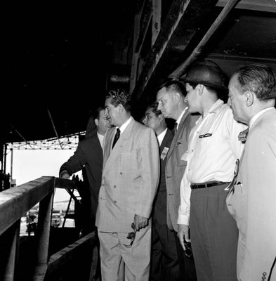 Adolfo López Mateos con otras personas, recorriendo las instalaciones de una planta industrial, durante su campaña electoral por Monclova