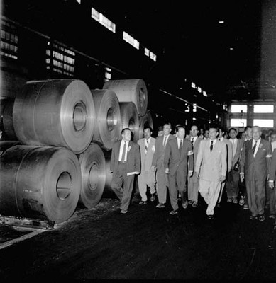 Adolfo López Mateos con otras personas recorriendo las instalaciones de una planta industrial, durante su campaña política por Monclova
