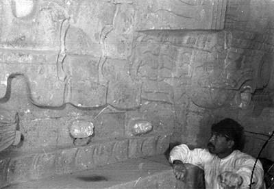 Hombre a un costado del tablero del Templo de Quetzalcóatl, vista parcial