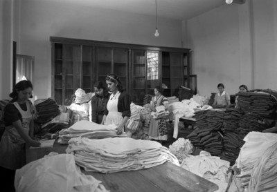 Mujeres laboran en el almacén de ropa de un taller textil