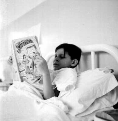 Niño lee una revista en una habitación