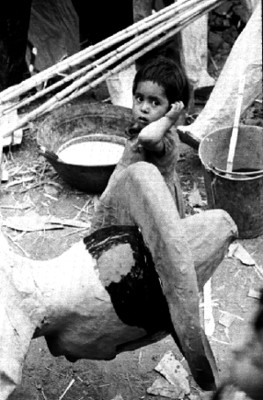 Niños observan judas de cartón en un patio