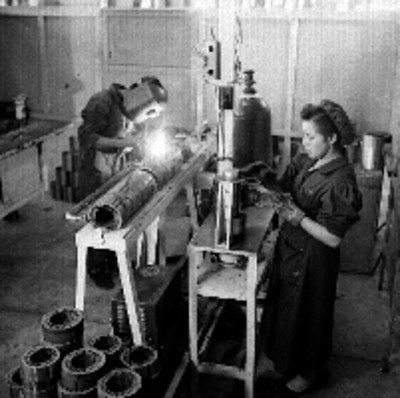 Obreros trabajan en la elaboración de bases para motor en la General Electric