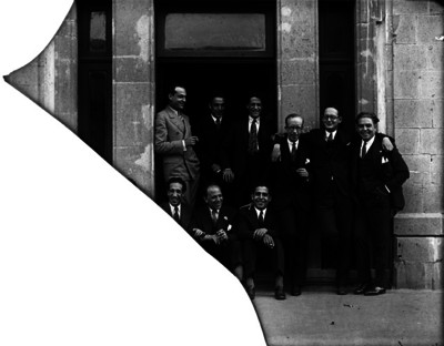 Ernesto García acompañado de varios hombres fuera de un edificio, retrato de grupo