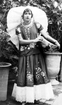 Mujer con traje de tehuana y artesanía