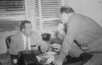 Alfonso Sanchez Tello conversando con otro hombre en una oficina