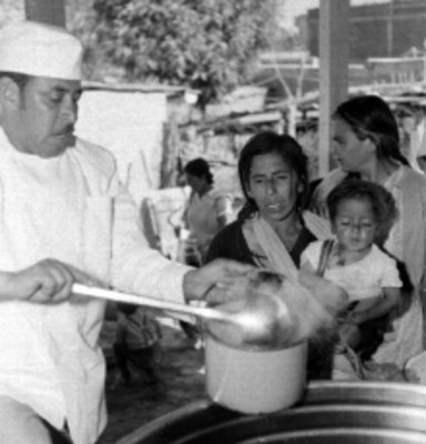 Cocinero repartiendo alimento de bajo precio a mujeres de clase humilde