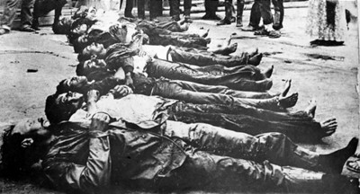 Personas observan cádaveres de revolucionarios en una explanada