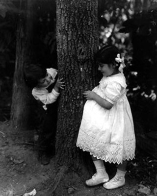 Niños juegan junto a un árbol