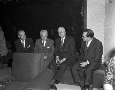 Hombres sentadas durante reunión en una casa