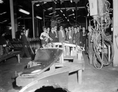 Ejecutivos observan procesos industrial en una fábrica automotríz