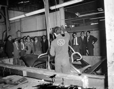 Visitantes observan carrocería de automóvil introducido en fasa en planta automotríz Volkwagen